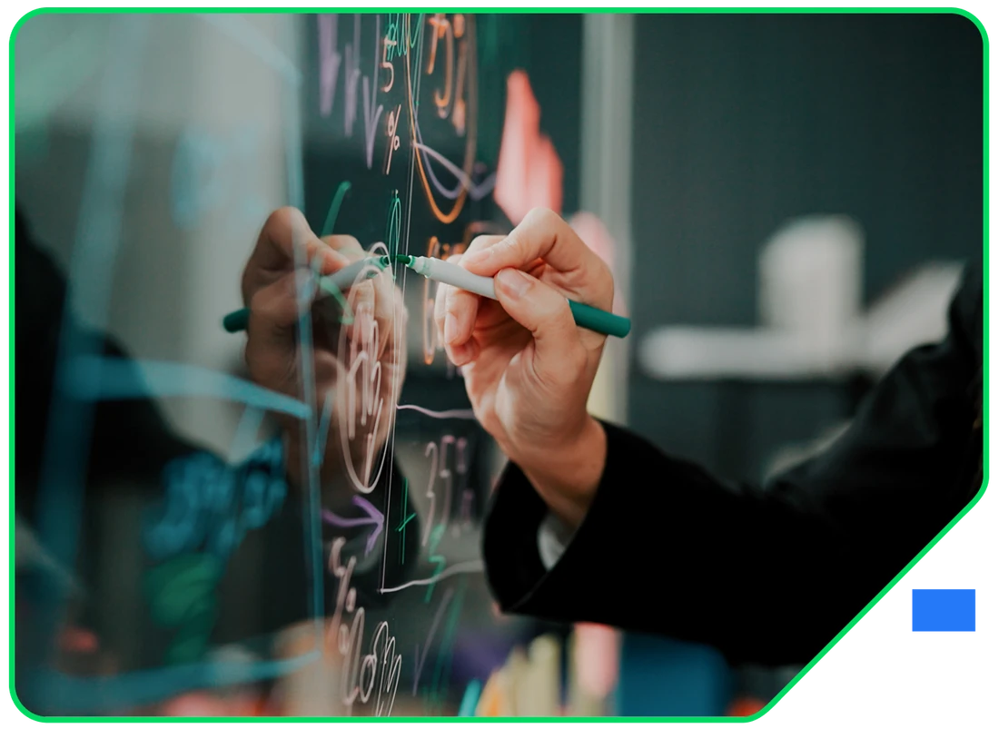 A hand mapping out diagrams and notes across a glass wall